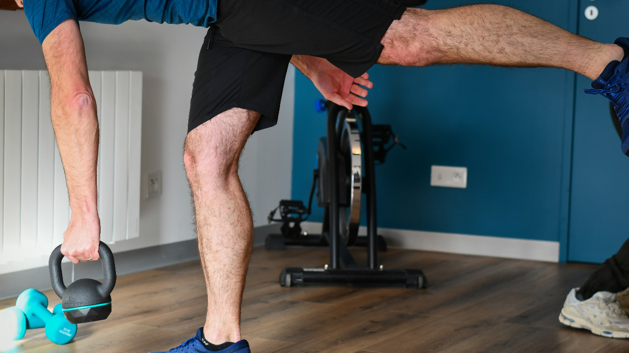 Un homme en équilibre effectue un exercice sportif avec une haltère